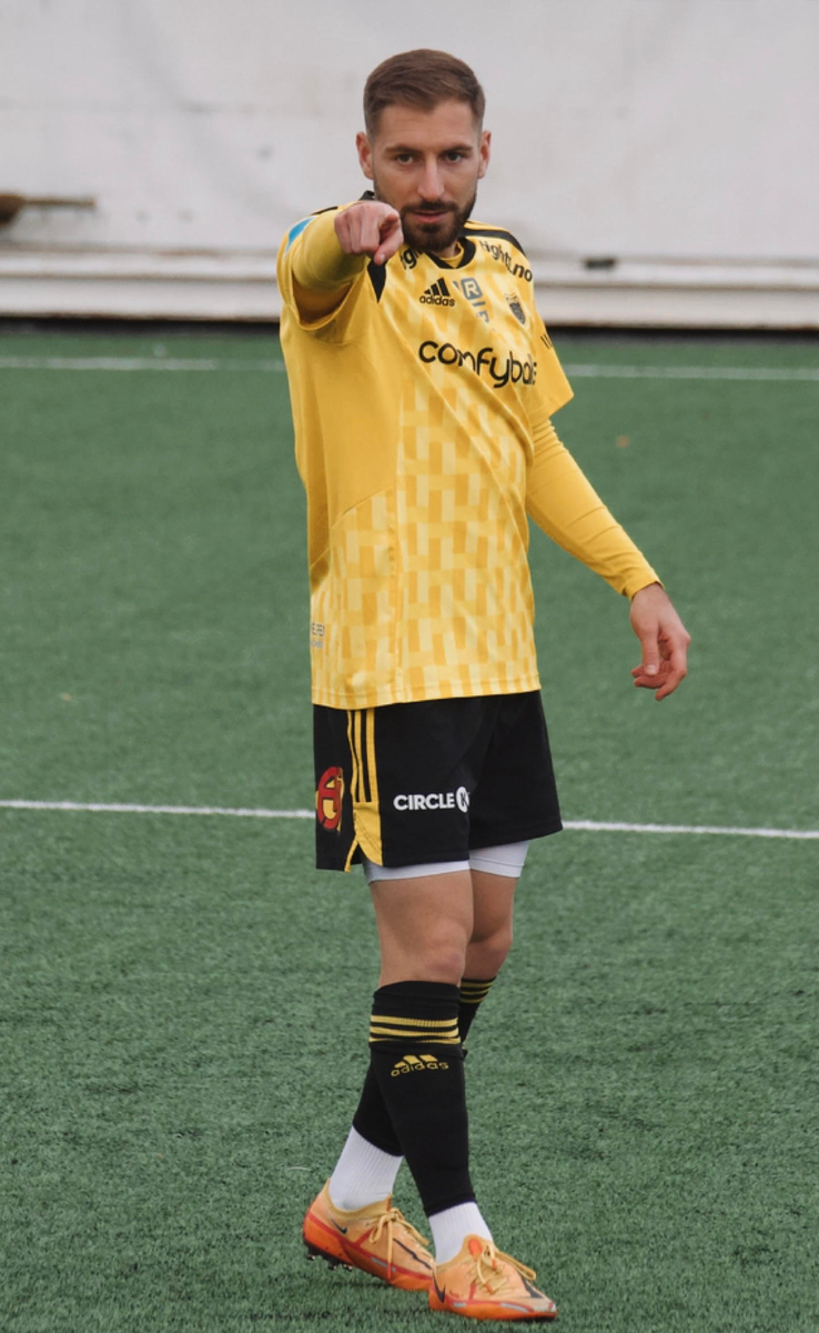 The coach is pointing to somebody during his football game.